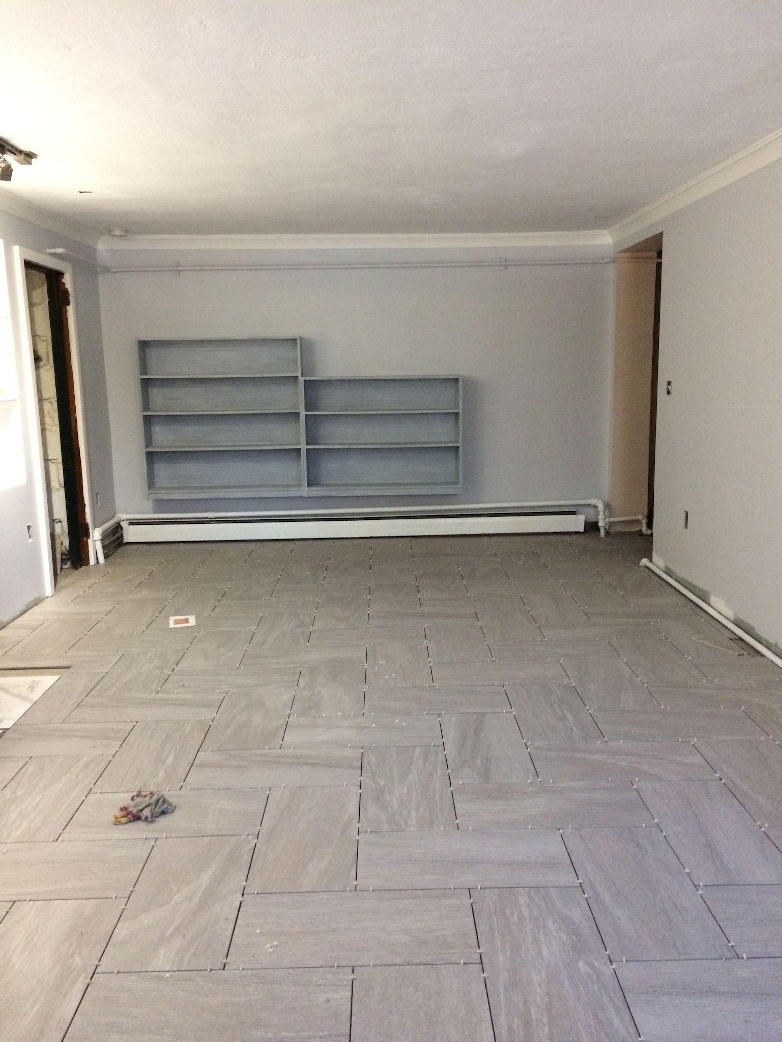 An empty room with a herringbone pattern on the floor