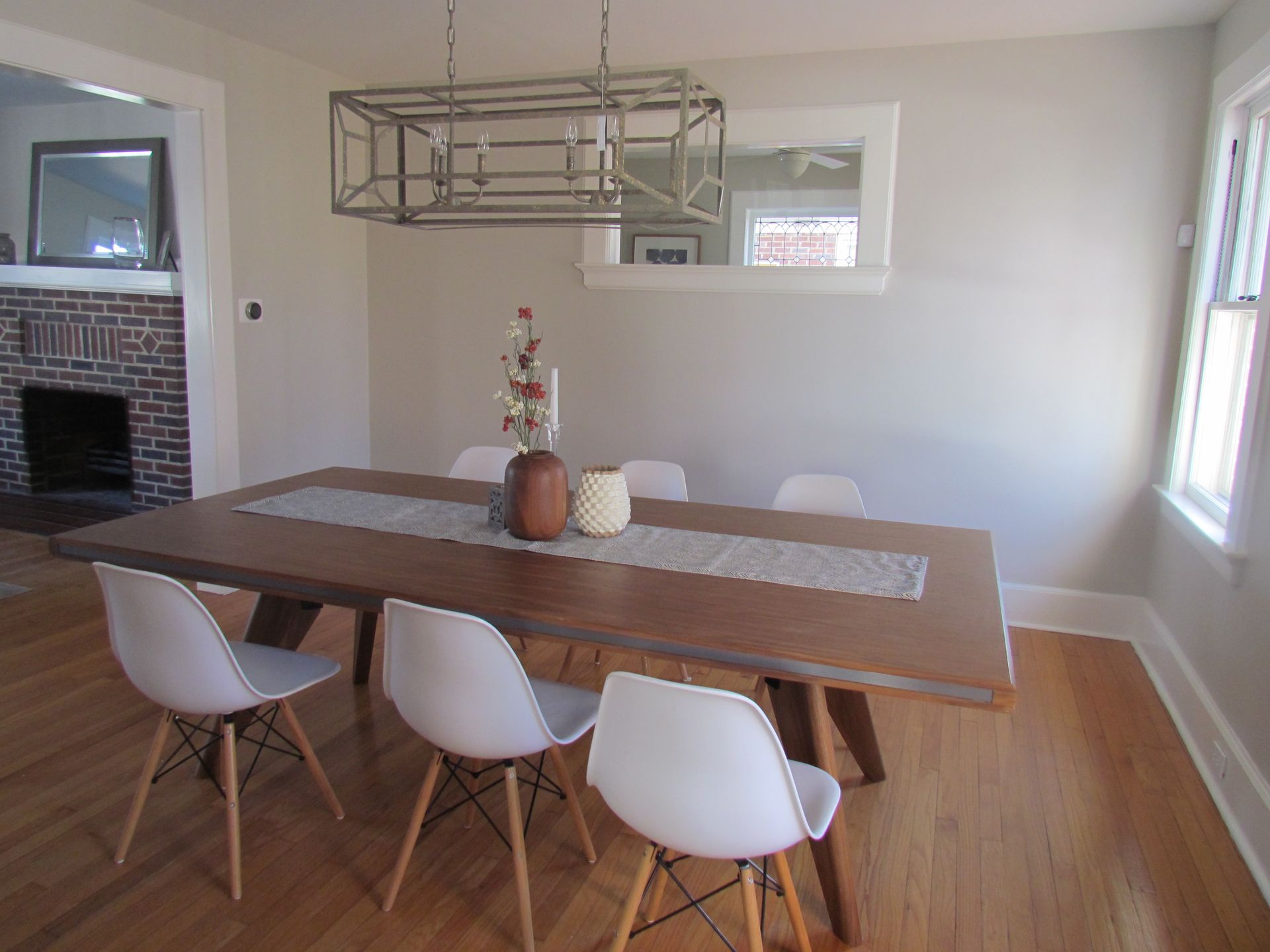 A dining room with a wooden table and white chairs