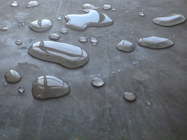 A close up of water drops on a concrete surface