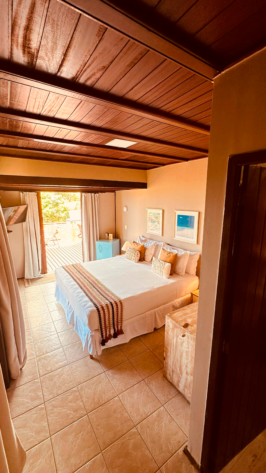 Um quarto com uma cama grande e teto de madeira.
