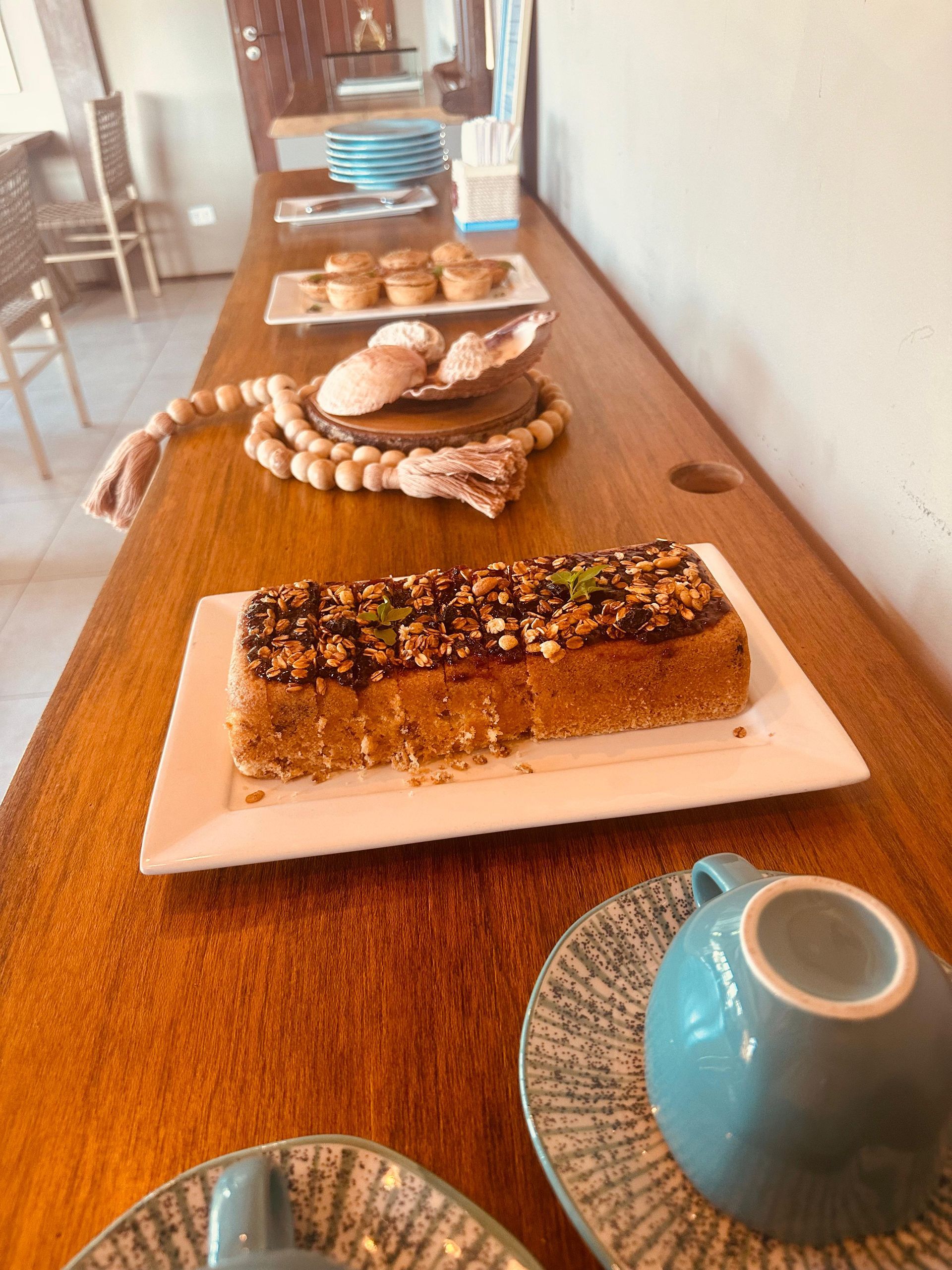 Uma mesa de madeira com pratos de comida e uma xícara de café