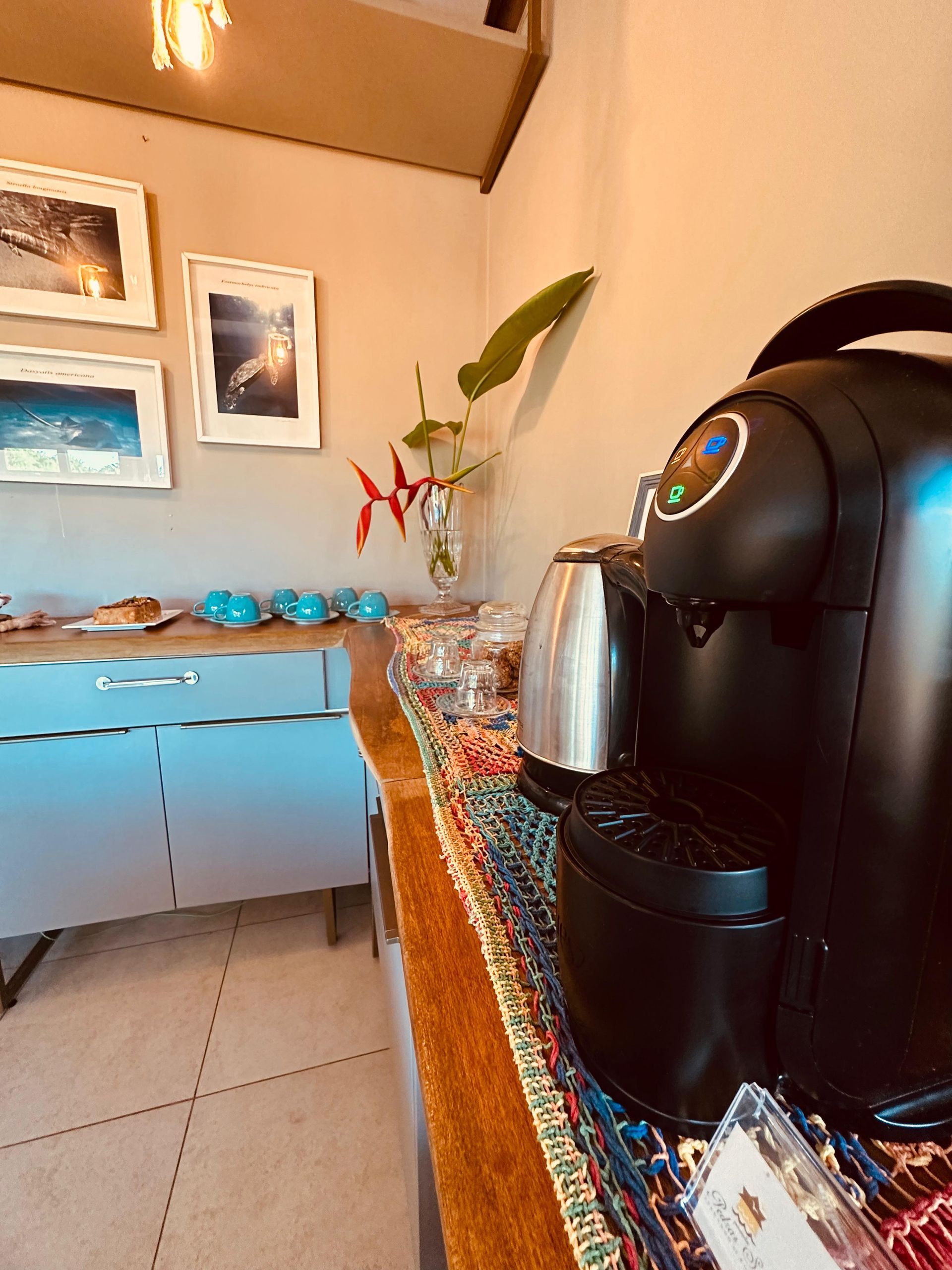 Uma cafeteira preta está sobre uma mesa em uma sala.