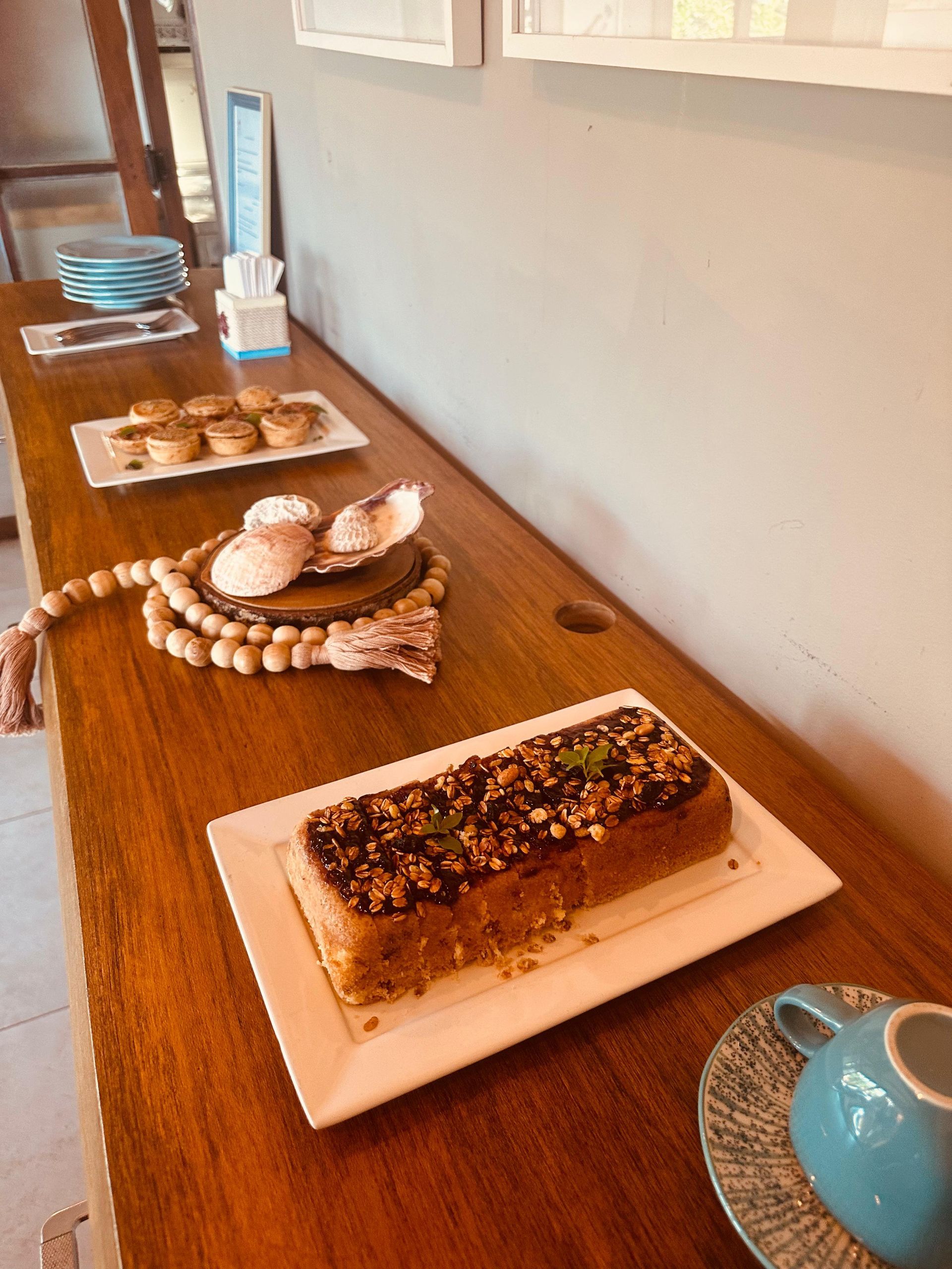 Uma mesa de madeira com pratos de comida e um pedaço de bolo