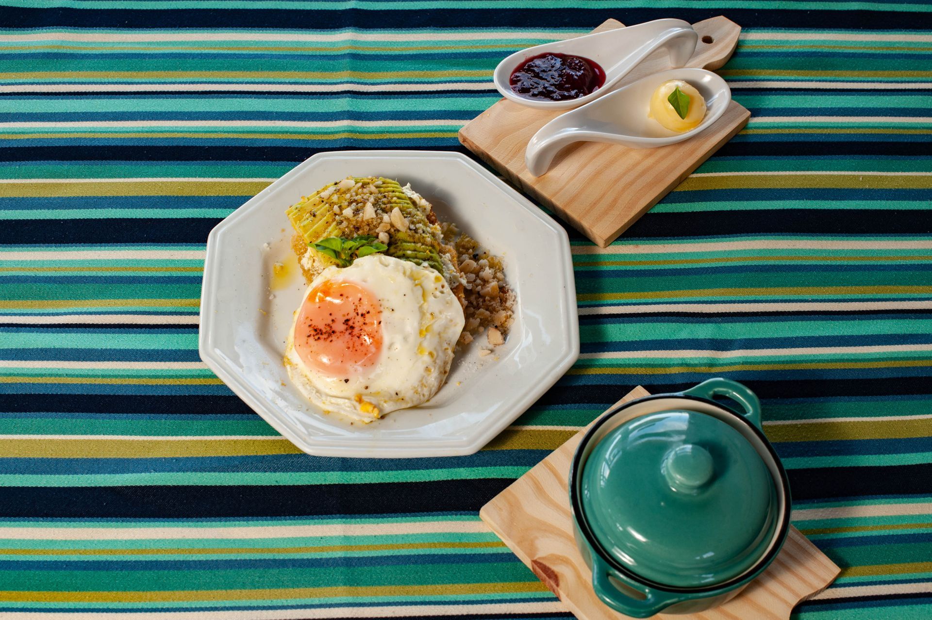 Um prato de comida está sobre uma toalha de mesa listrada.