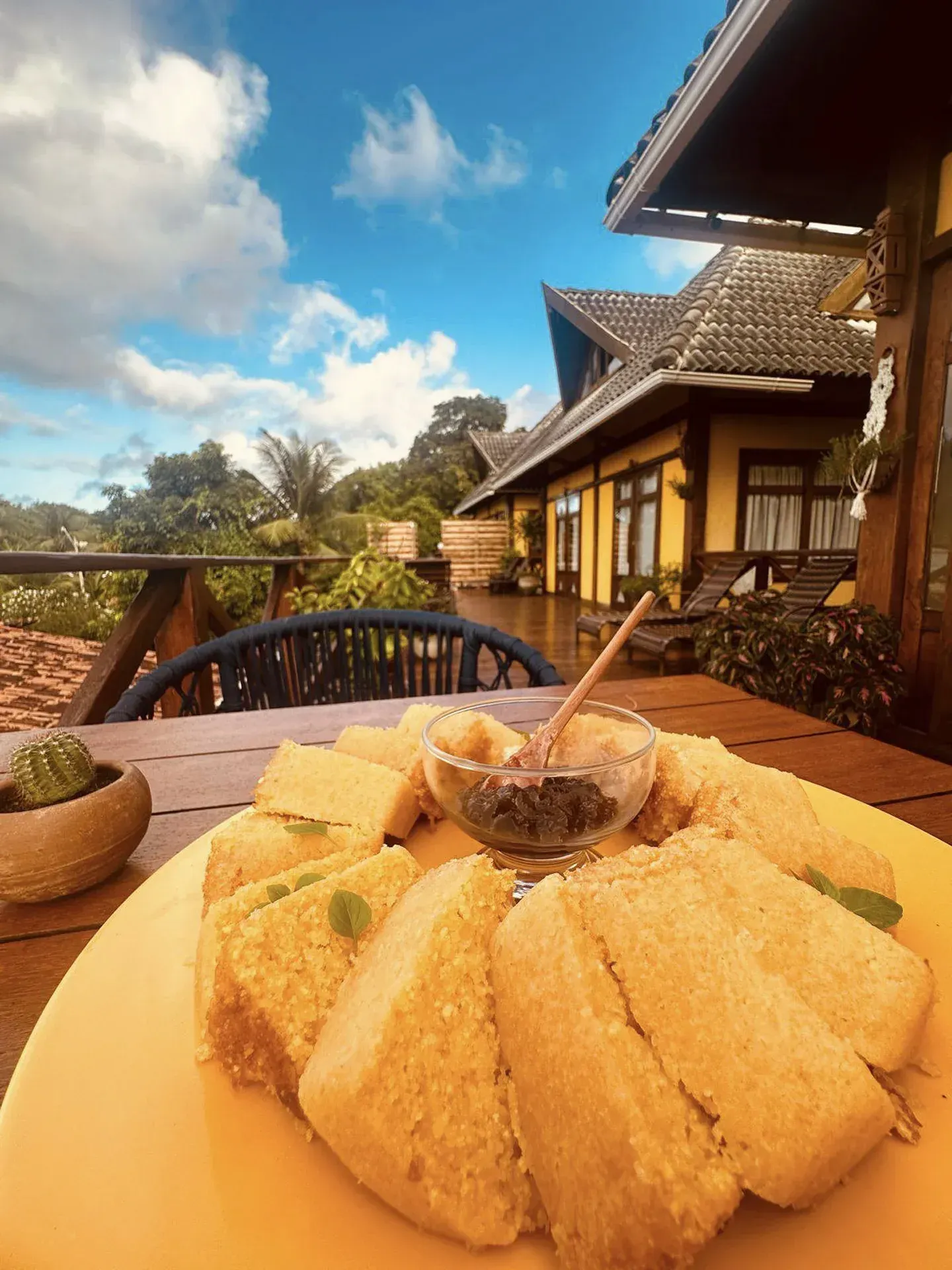 Um prato de comida sobre uma mesa com uma casa ao fundo.