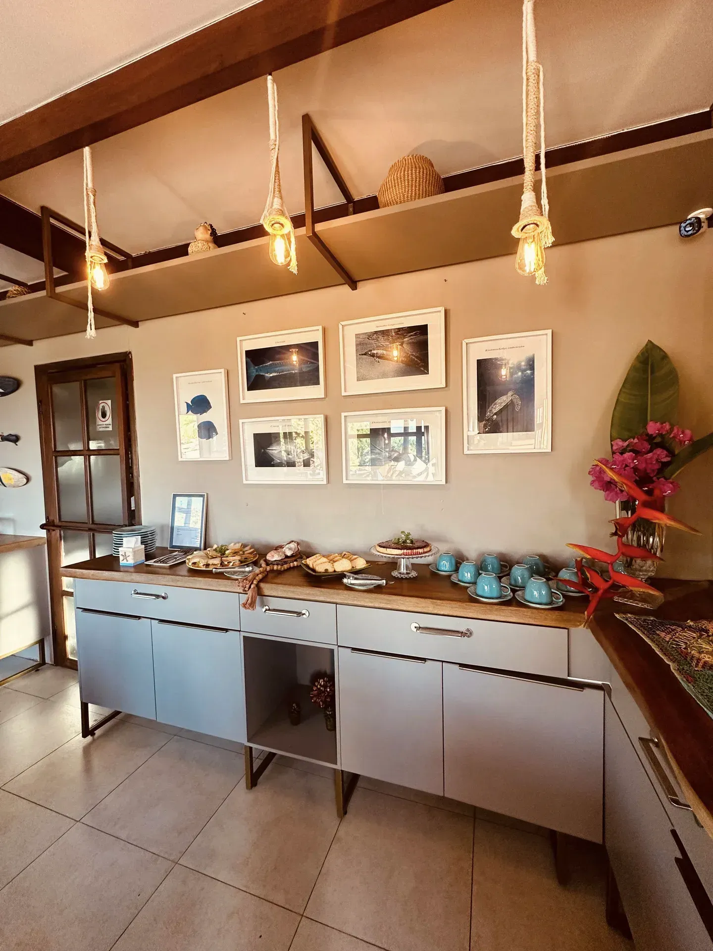 Uma cozinha com uma mesa de bufê e quadros na parede.