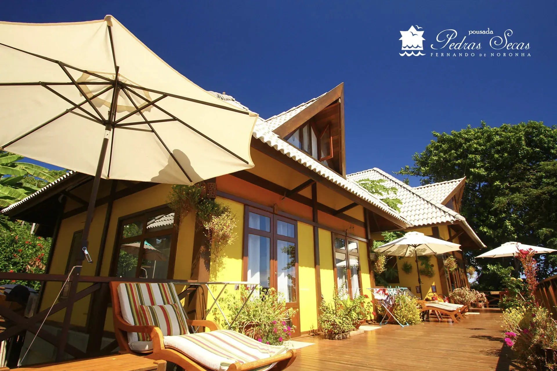 Uma casa amarela com um guarda-chuva branco na frente