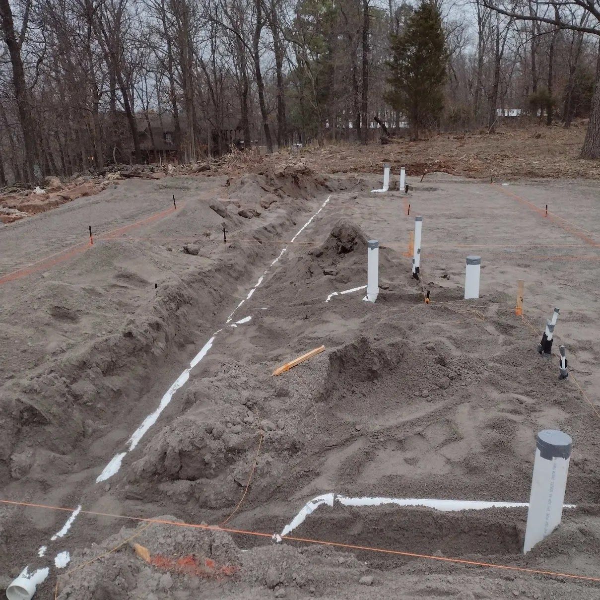 Construction site with plumbing pipes laid in trenches.