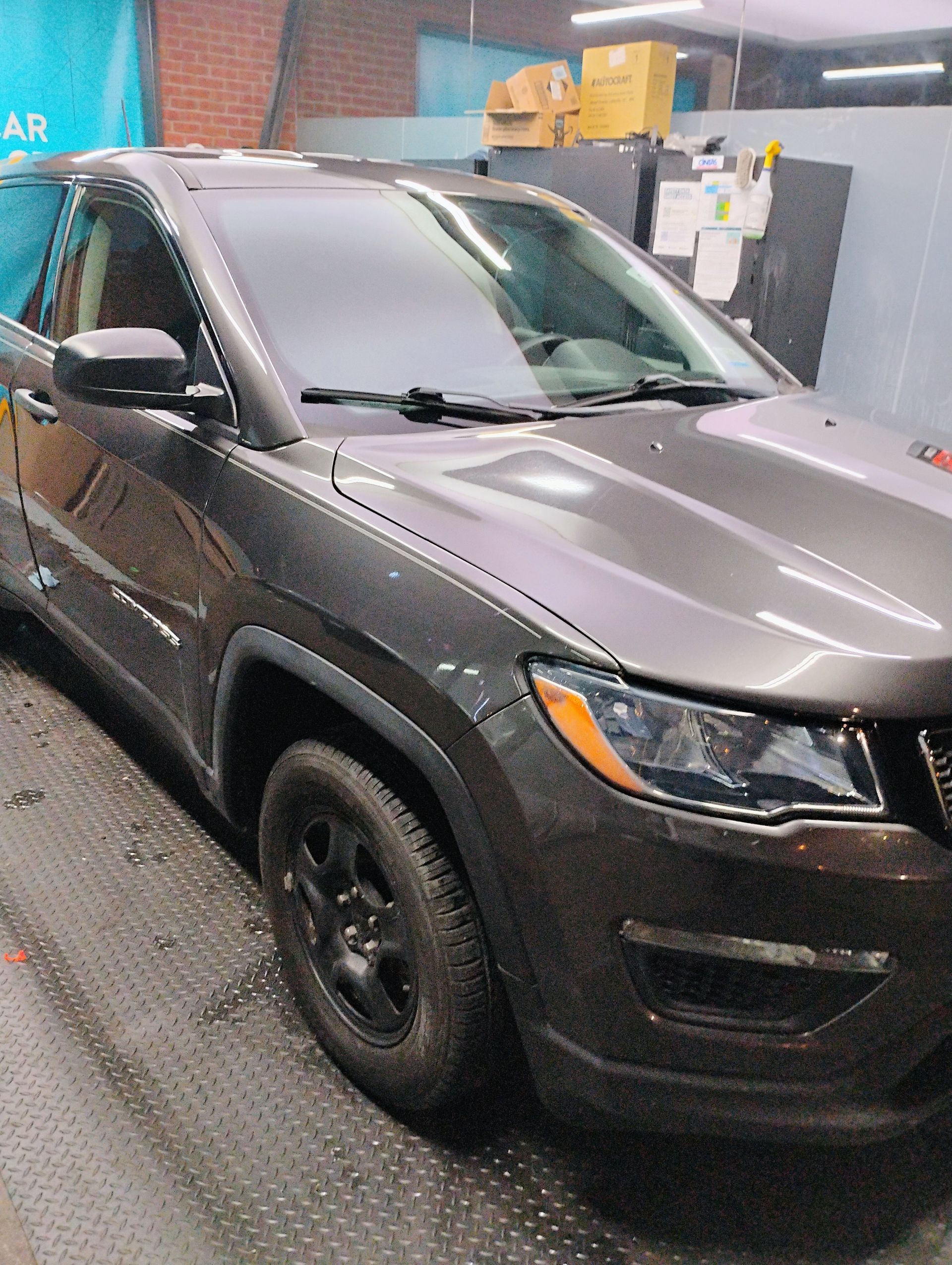 A jeep compass is parked in a garage.