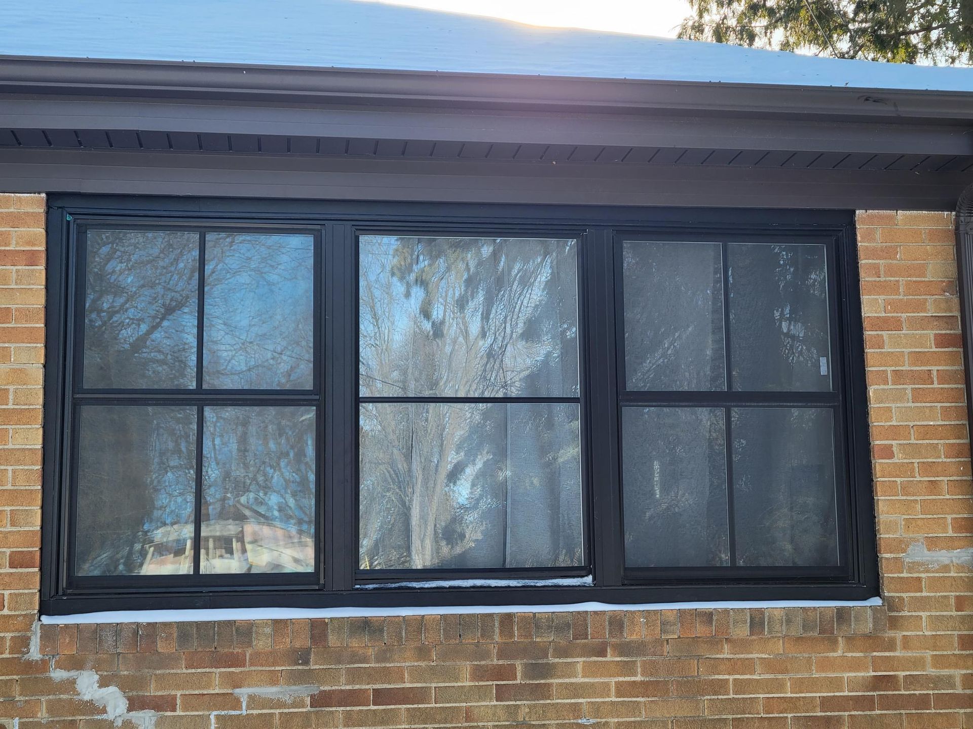 A brick building with a black window on it