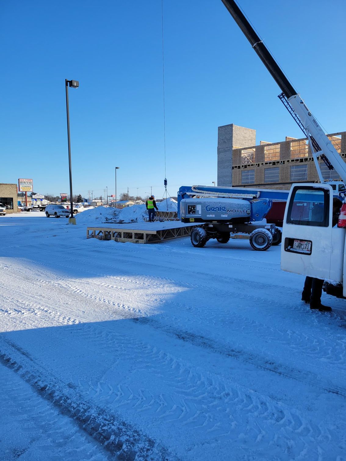 A white truck is parked in a snowy parking lot