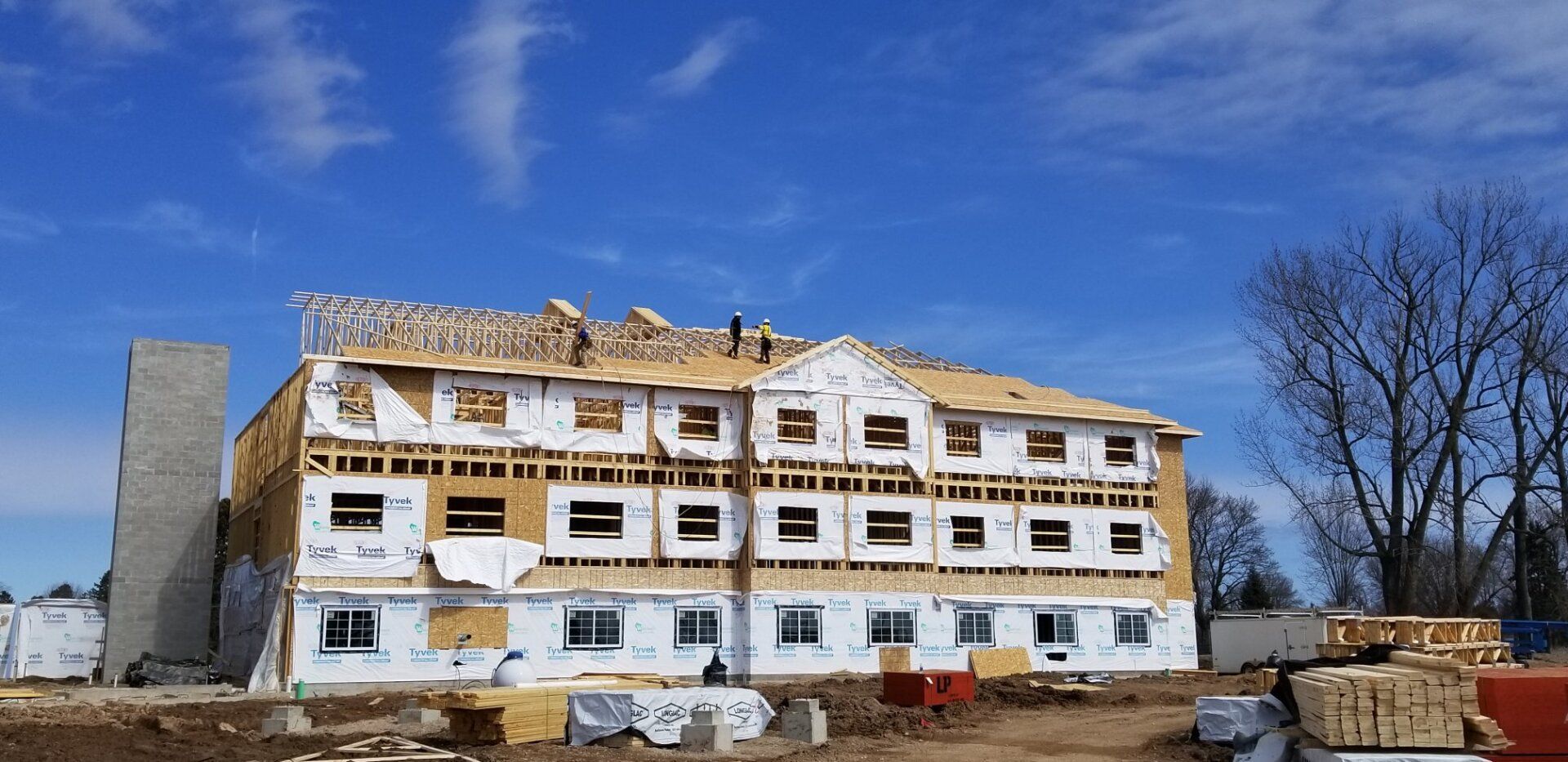 A large building under construction with a blue sky in the background.