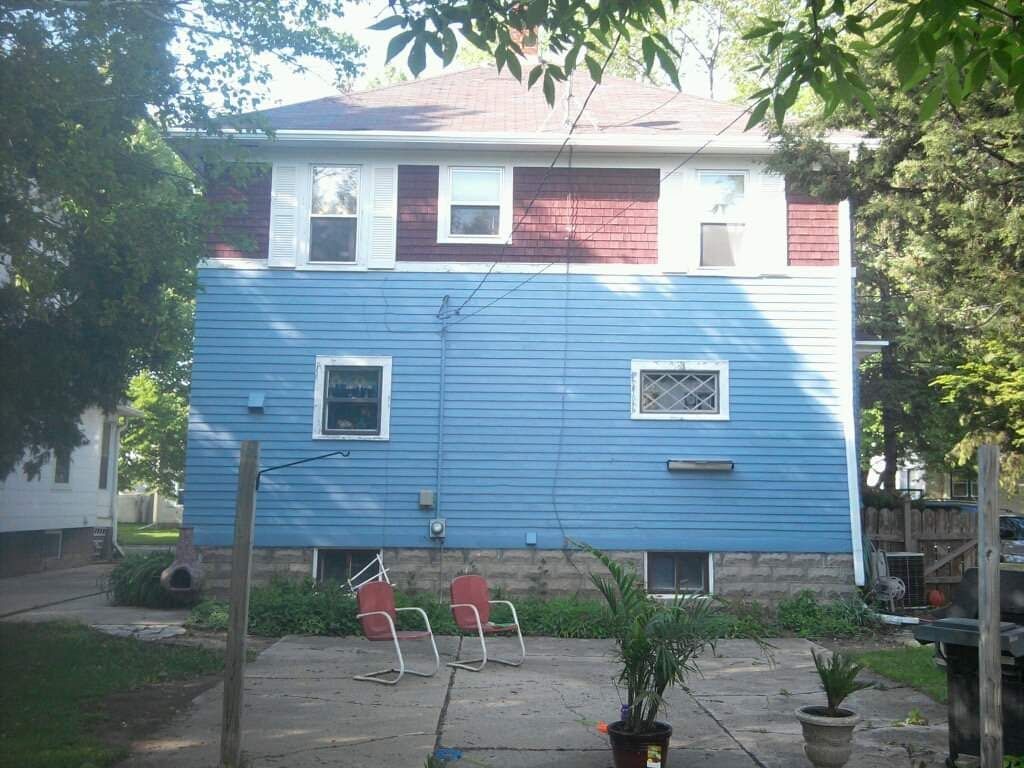 A blue house with a red roof and white trim
