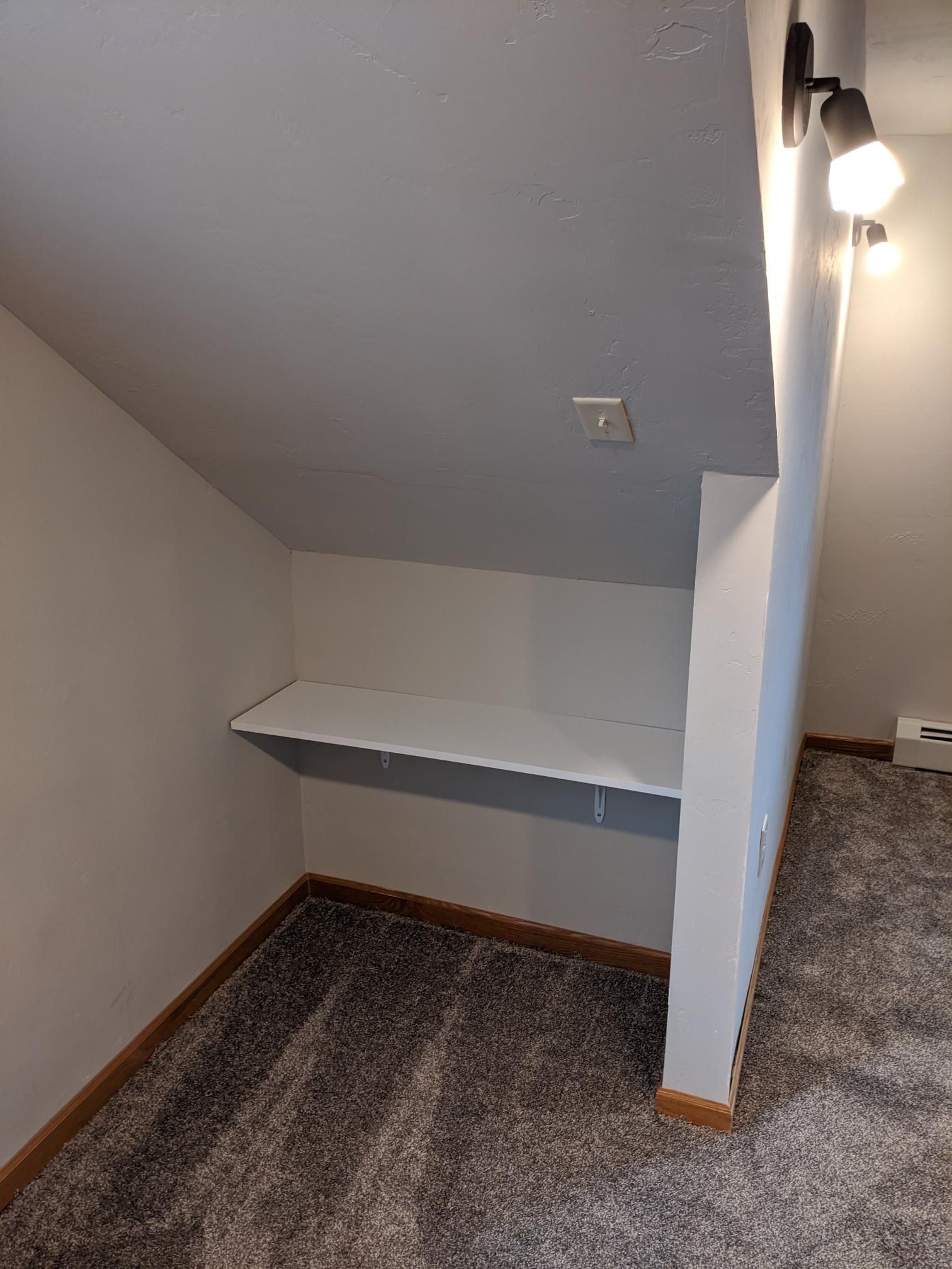 There is a shelf in the corner of the room.