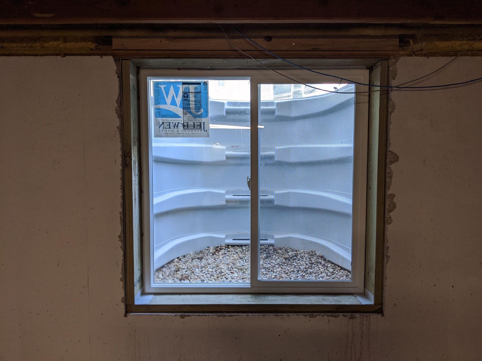 A window in a basement with a sliding glass door.