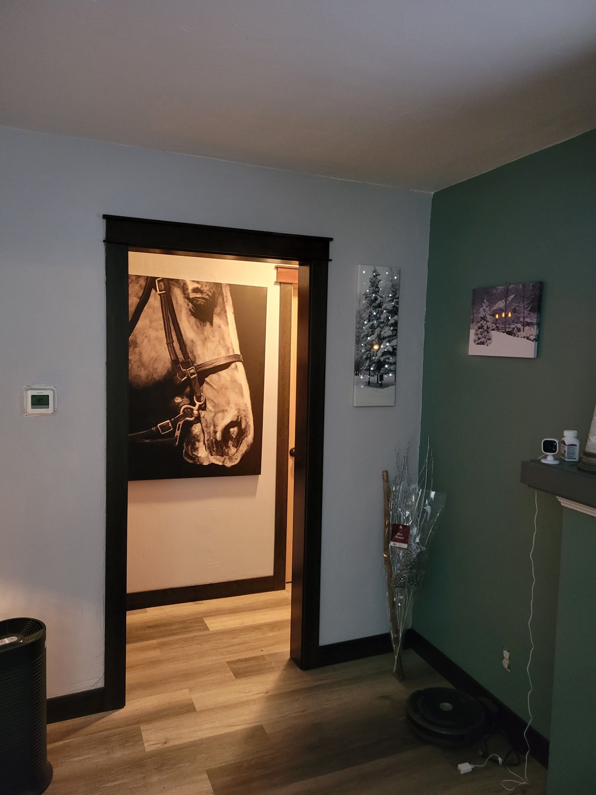 A room with a painting of a horse on the wall.