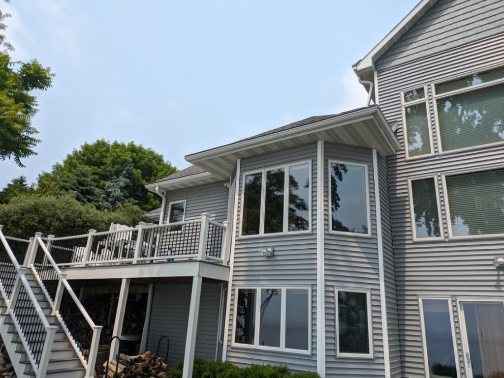 A large gray house with a deck and stairs