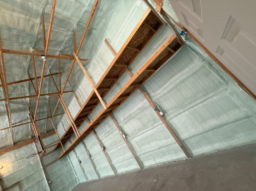Interior of a building with wooden beams and spray foam insulation on the walls and ceiling.