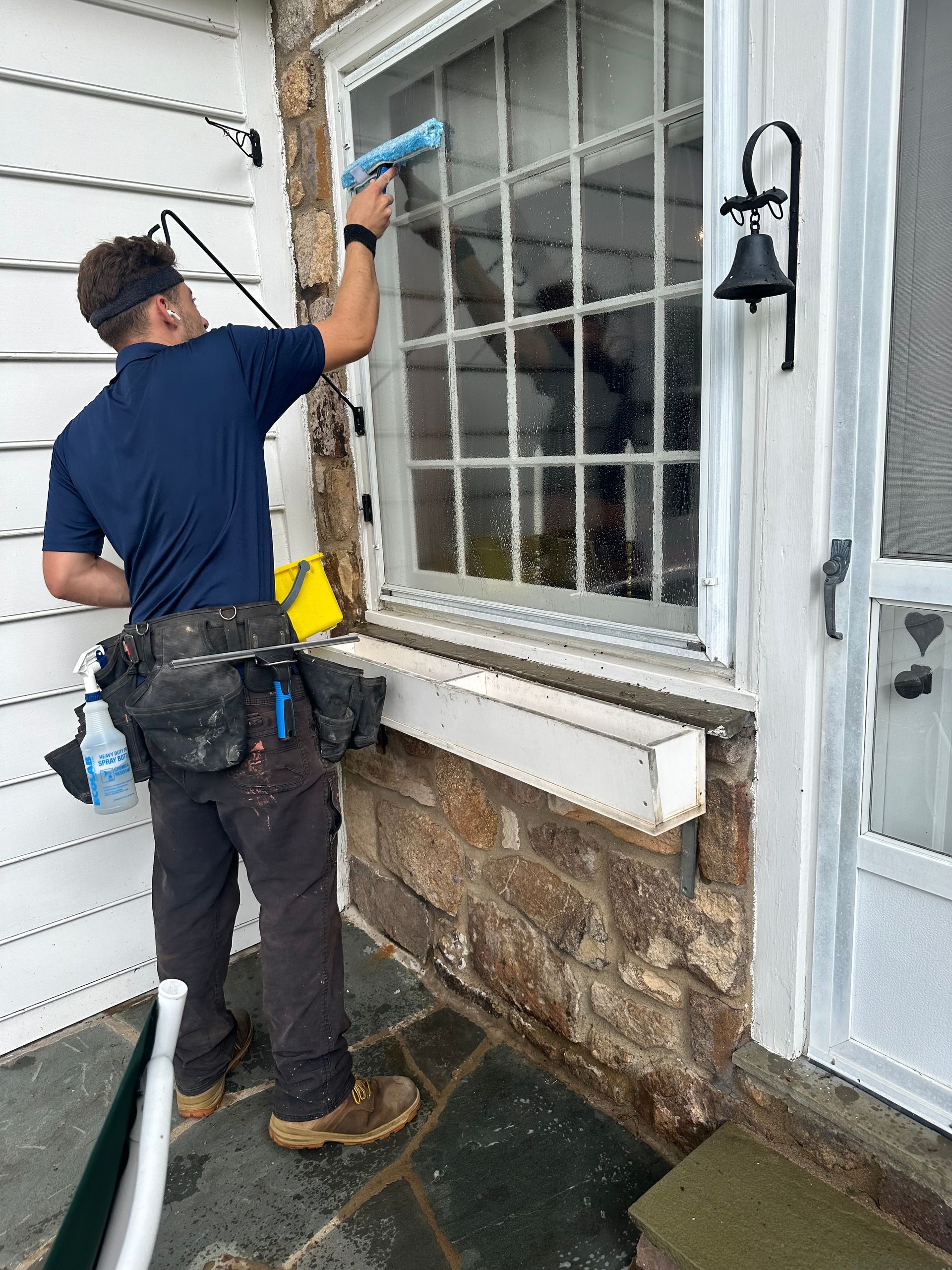 A man is cleaning a window with a squeegee.