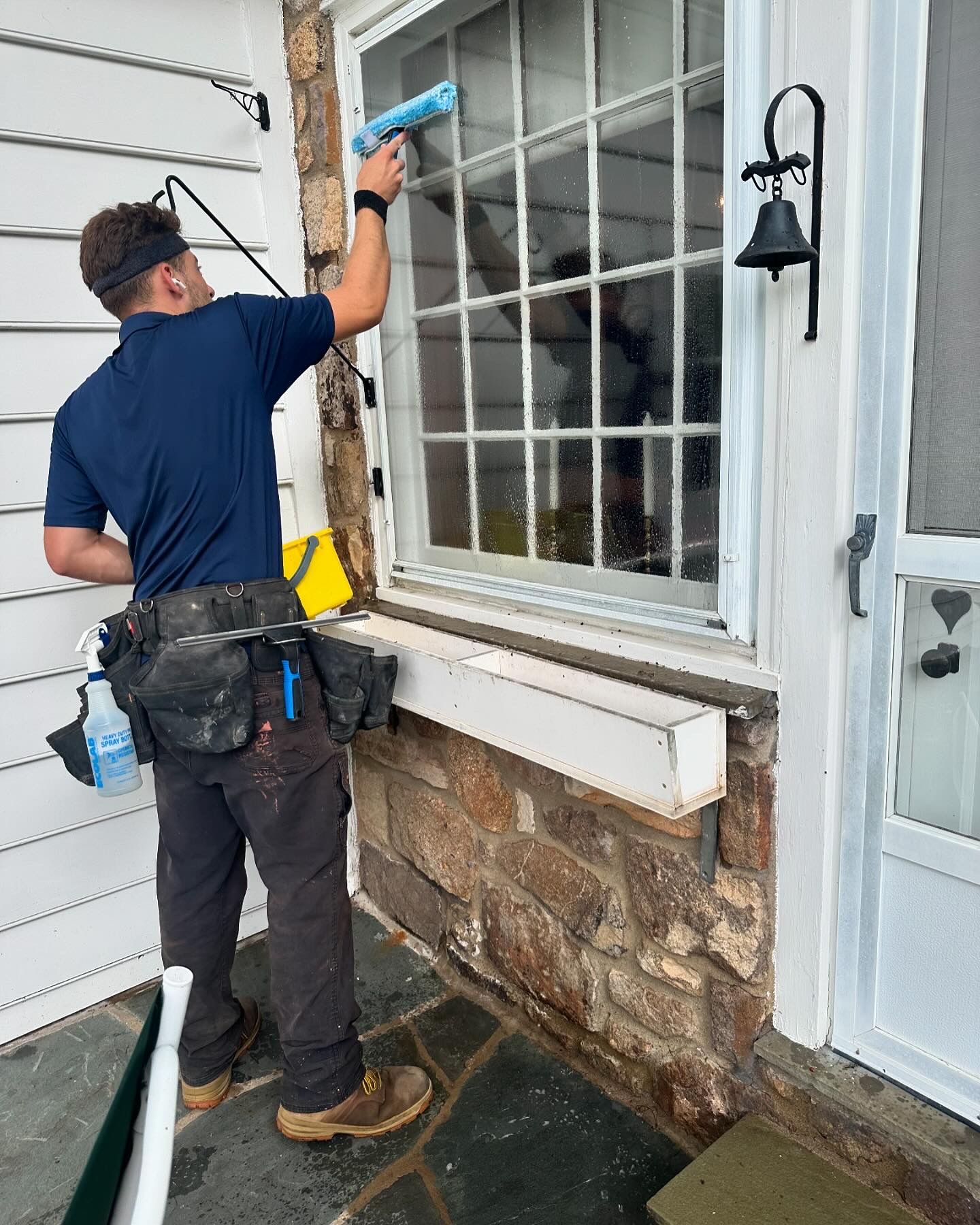 A man is cleaning a window with a squeegee.