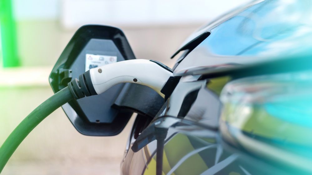 An electric car is being charged at a charging station.
