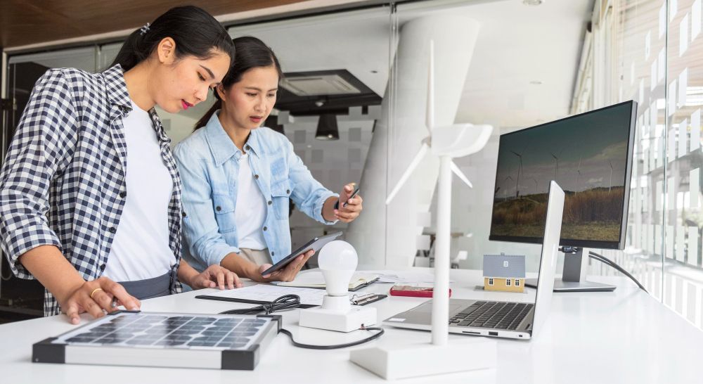 Two women are working on a project in an office.