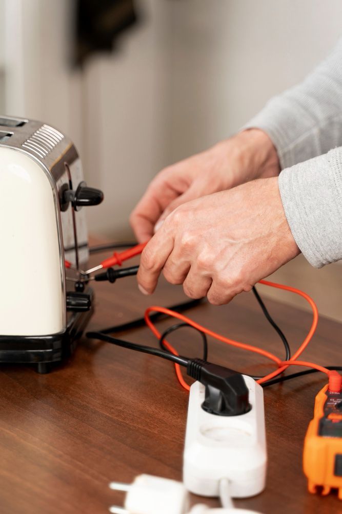A person is fixing a toaster on a wooden table.
