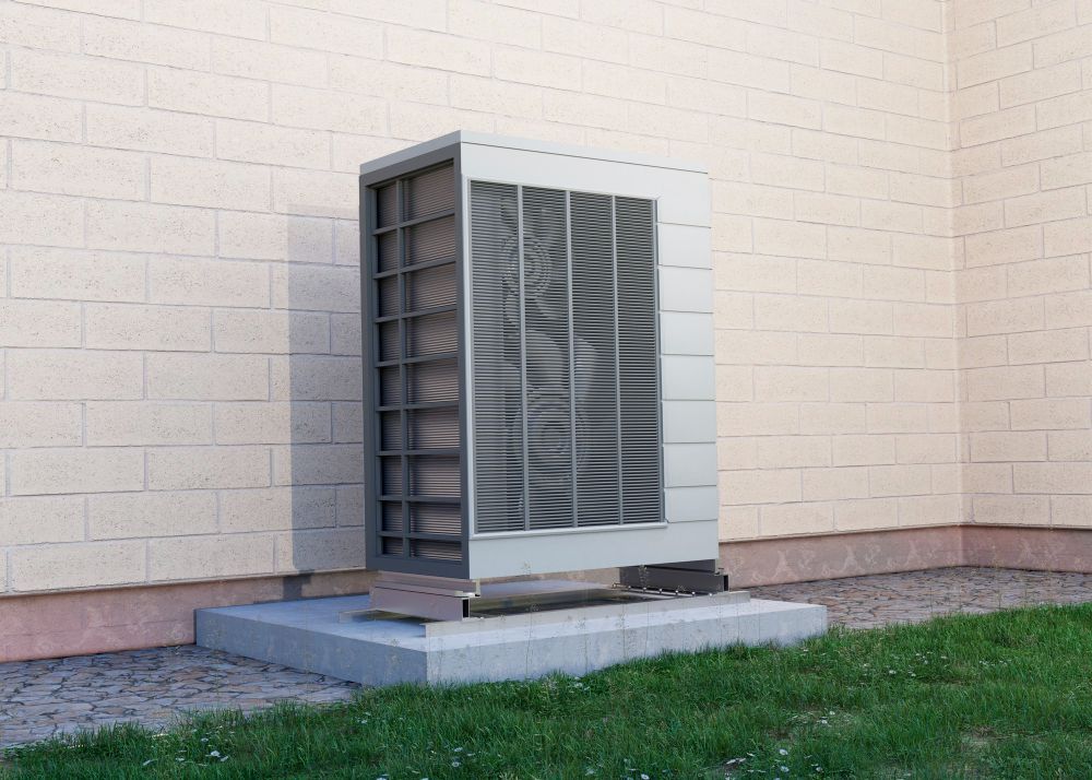 A large air conditioner is sitting on the side of a brick building.