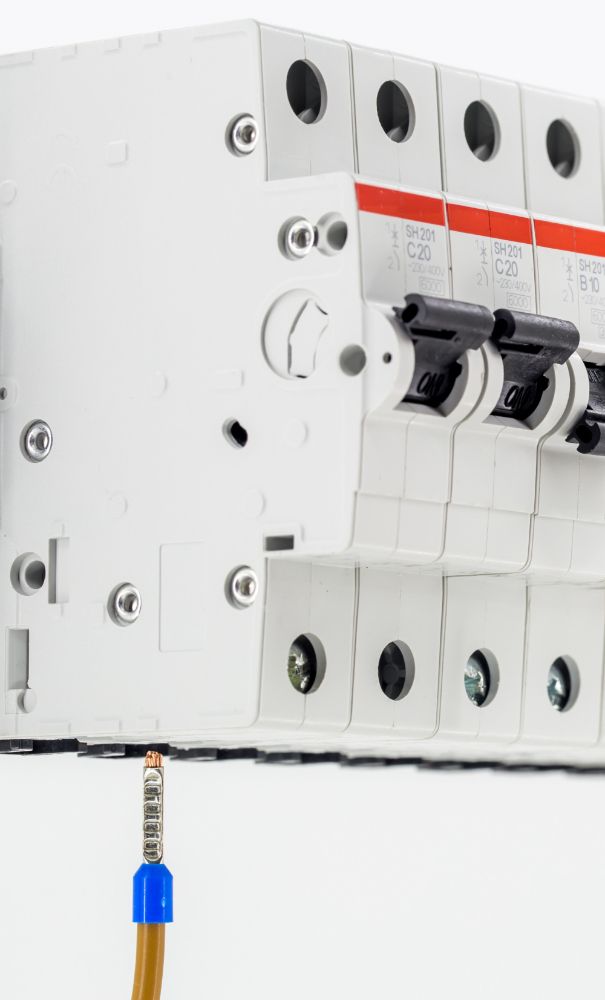 A close up of a circuit breaker with a wire attached to it.