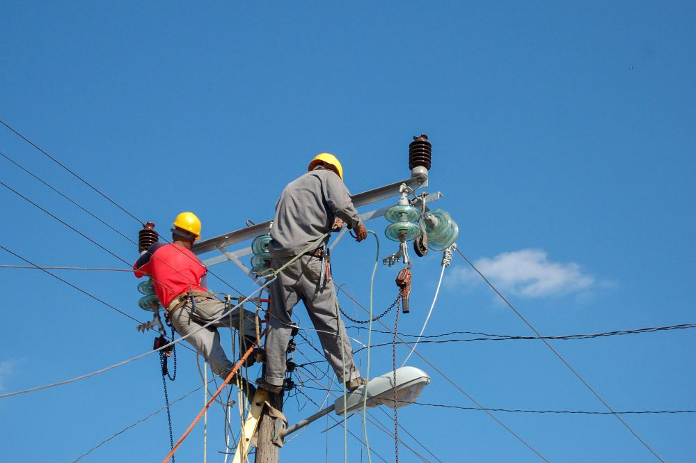 Two men are working on a power line.