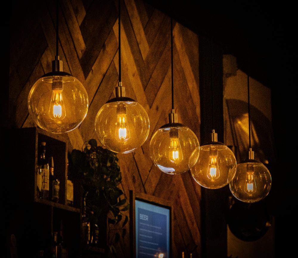 A row of light bulbs hanging from the ceiling in a dark room.