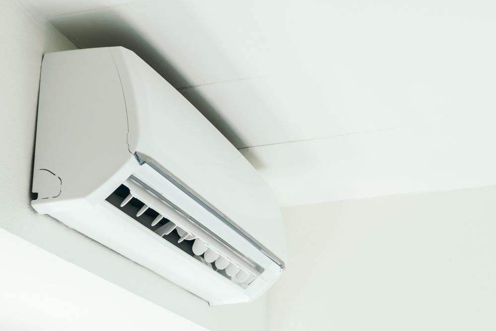 A white air conditioner is hanging from the ceiling