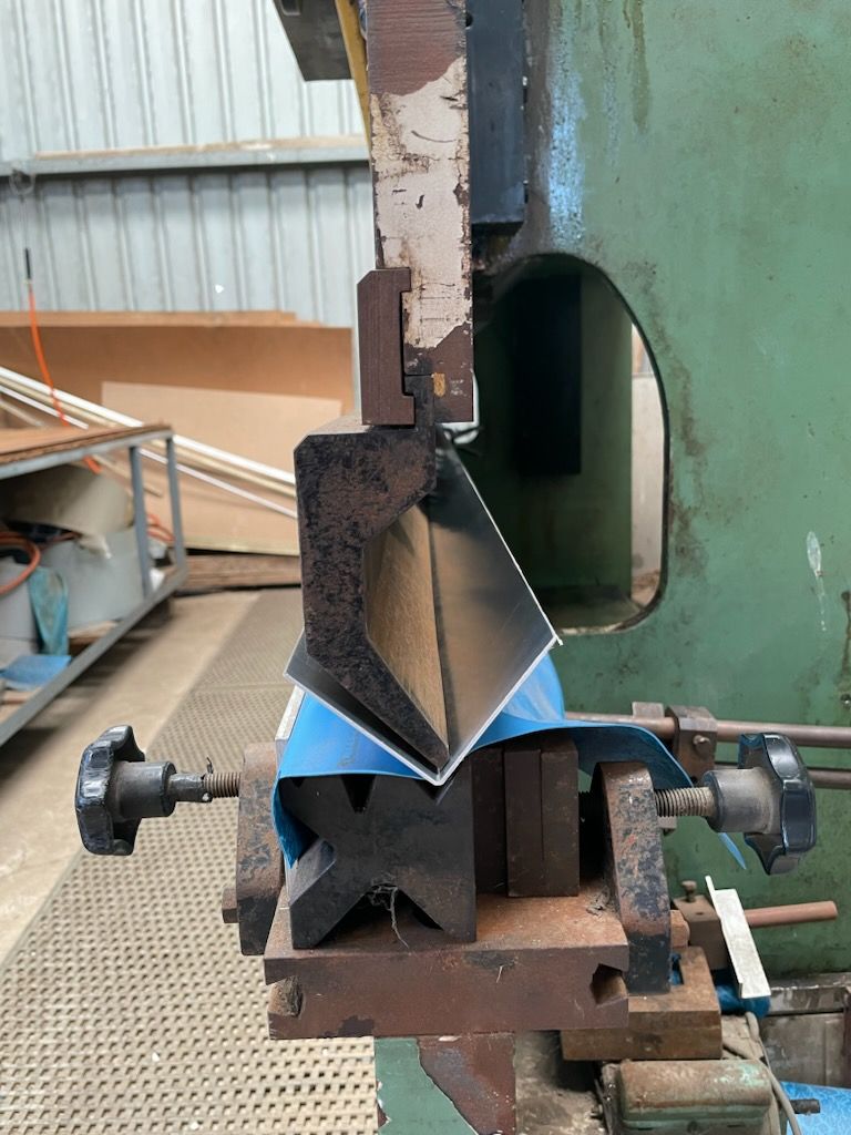 A machine is bending a piece of metal in a factory  | Berkshire Park, NSW | V.J.S. Aluminium & Steel