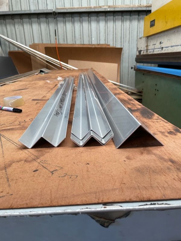 Three pieces of metal are stacked on top of each other on a wooden table  | Berkshire Park, NSW | V.J.S. Aluminium & Steel