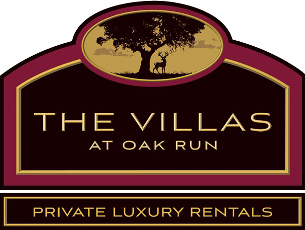 Logo for "The Villas at Oak Run," featuring a tree and deer, burgundy and gold.