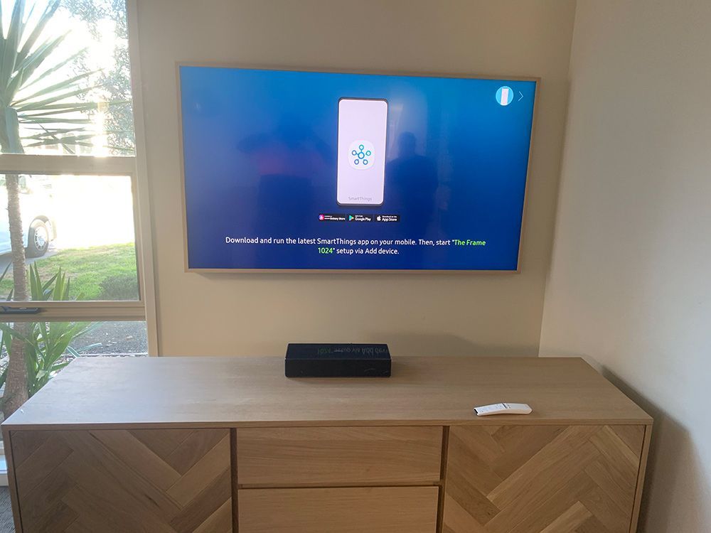 Tv Is Mounted On A Wall Above A Wooden Center — Telecommunication Company In Googong, NSW