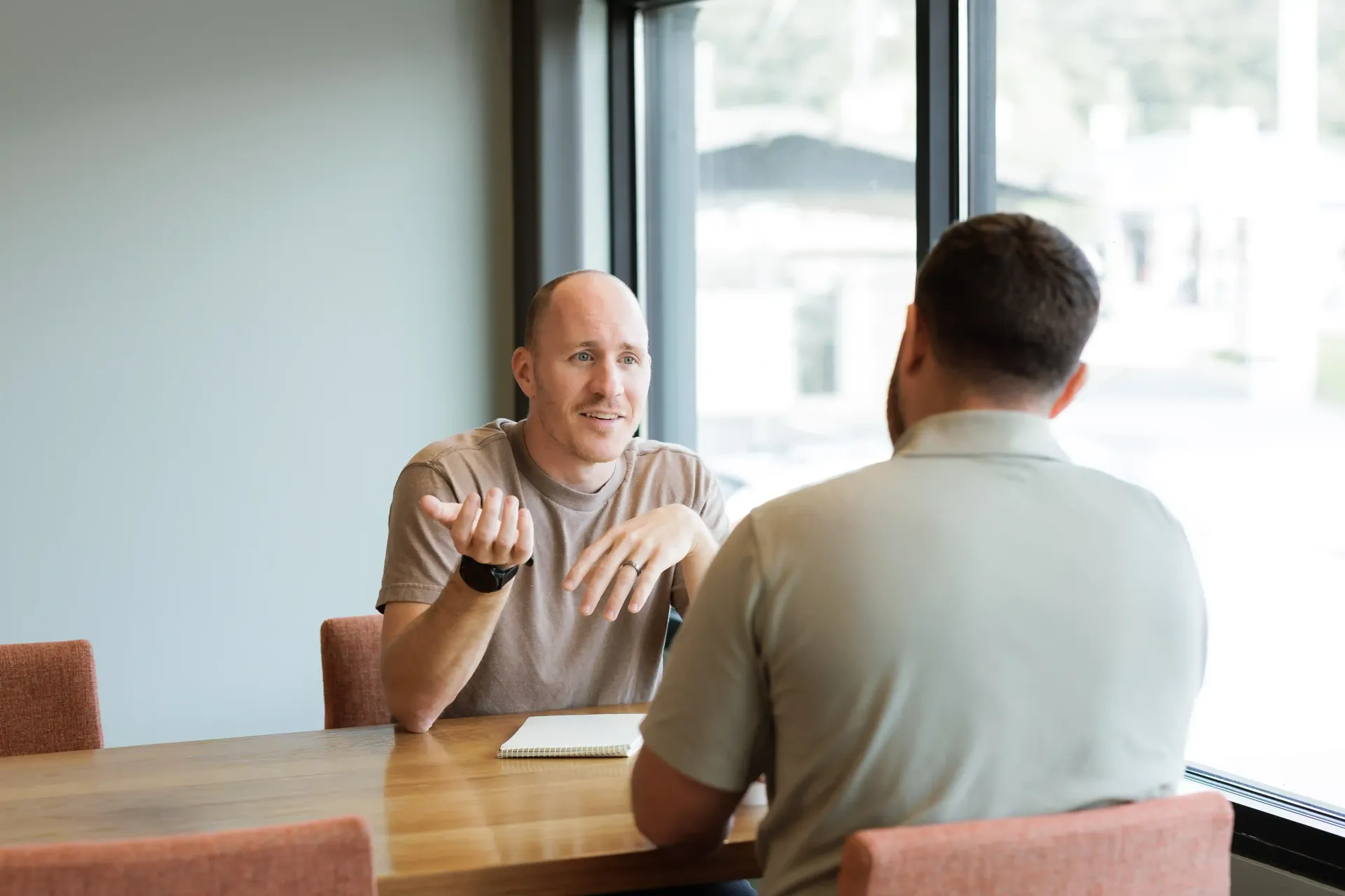 Career Coach Adam Broda Discussing Career Transition Strategy with Client at Table