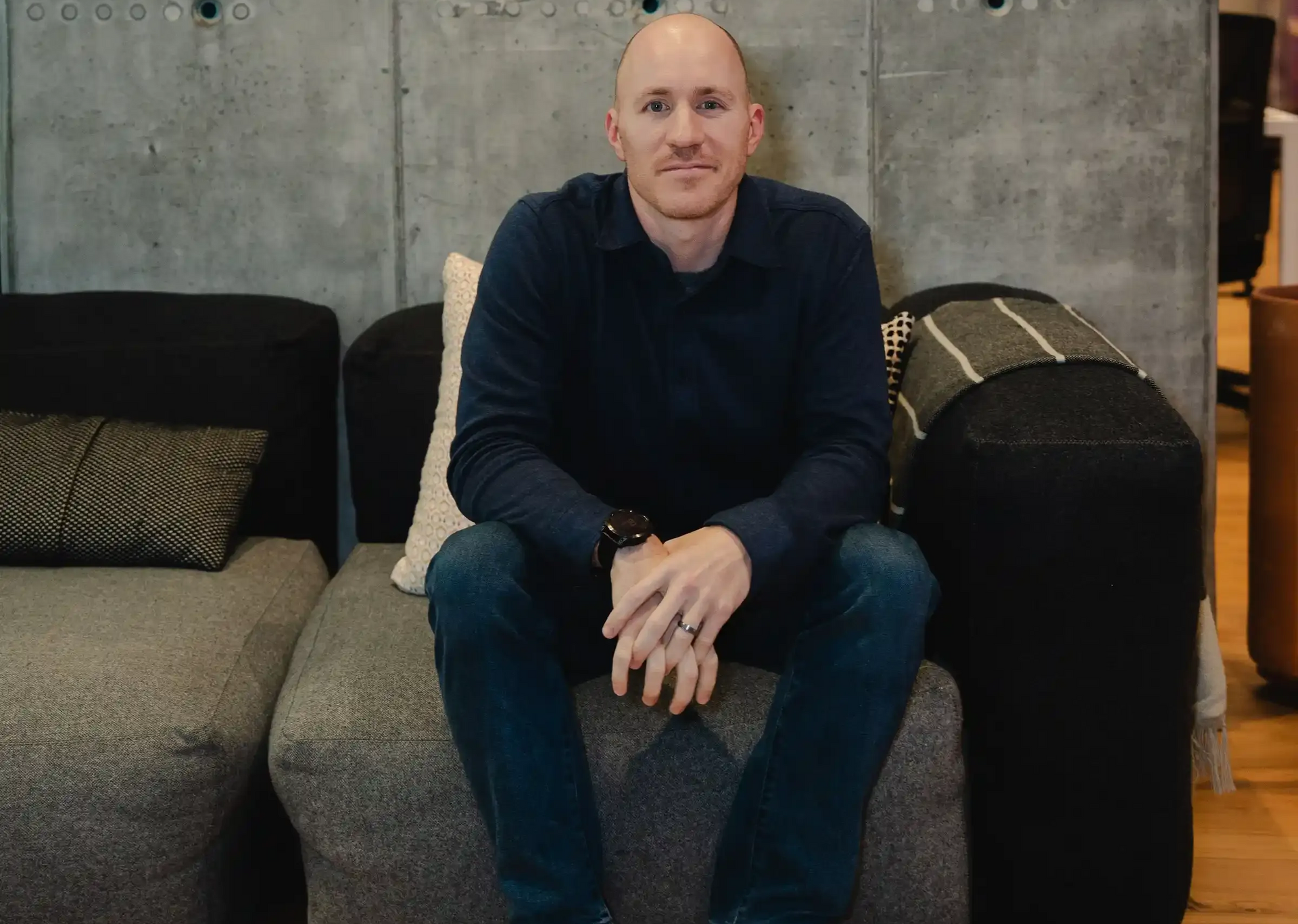 Career Coach Adam Broda Sitting on Couch Smiling Ready to Guide Career Transition