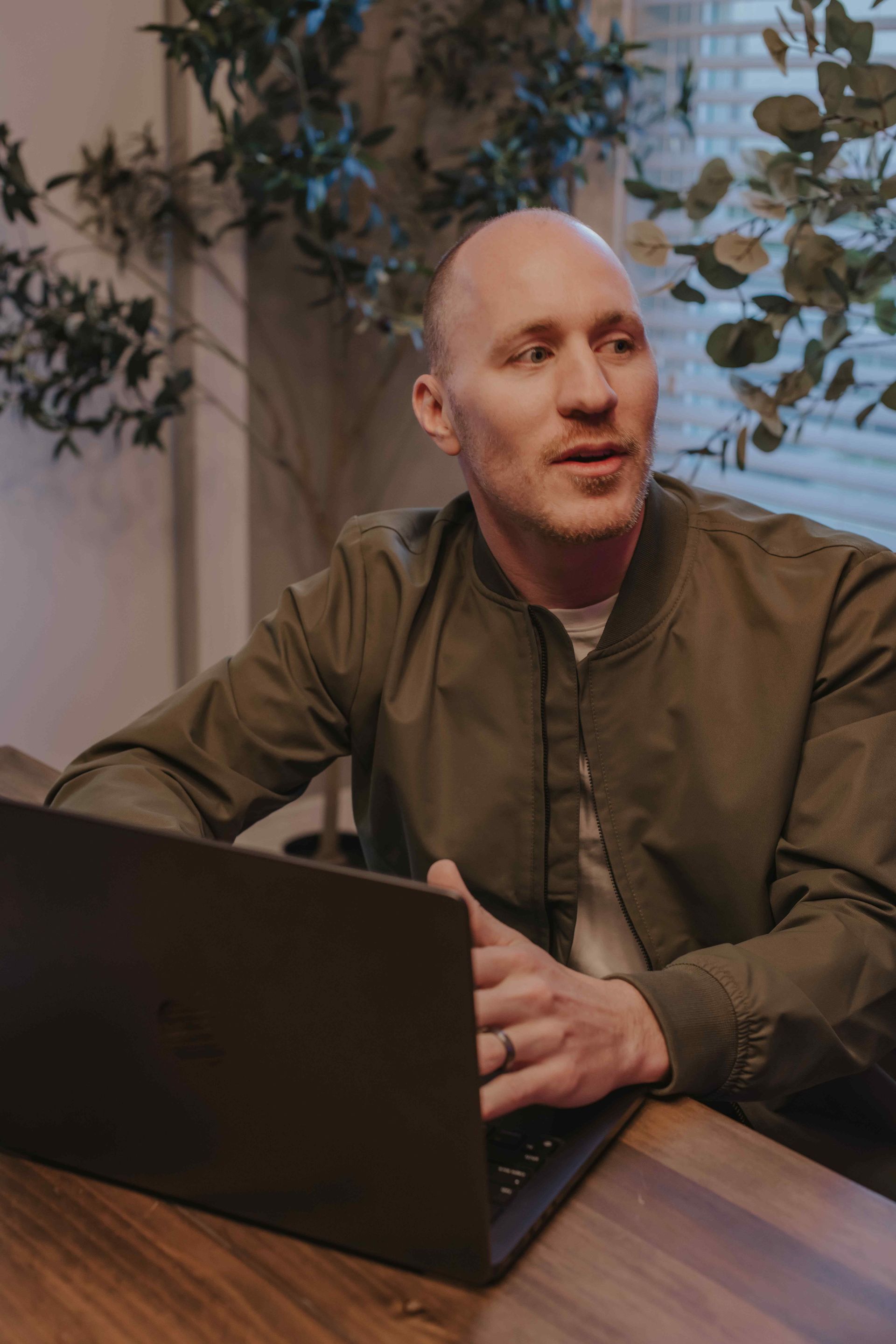 Coach Adam Broda Sitting At Table With Laptop Explaining Concepts