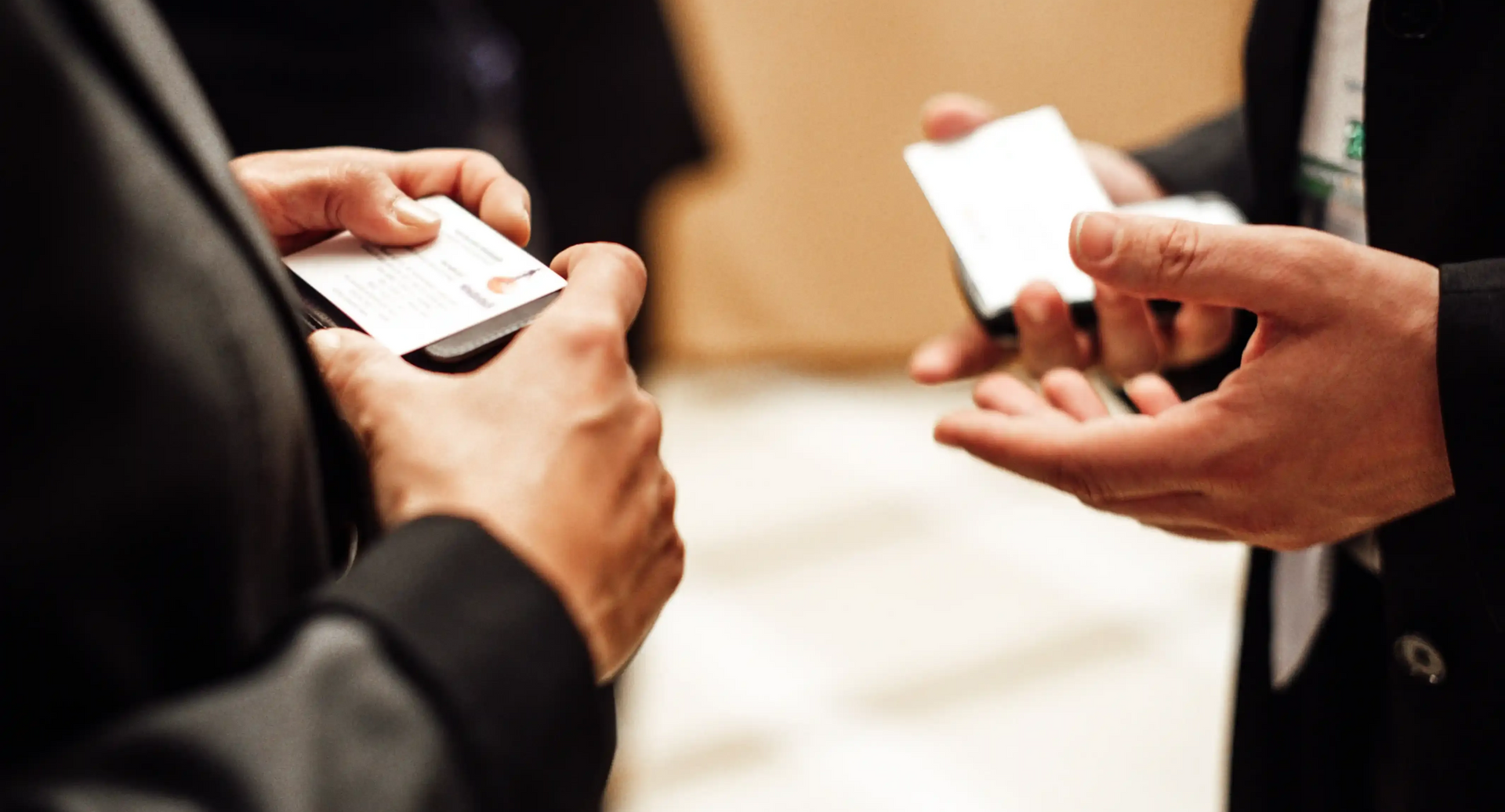 Senior Level Professionals Exchanging Business Cards At Networking Event