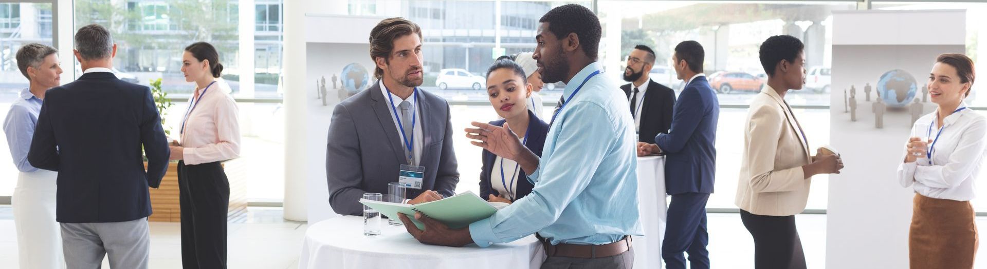 A group of people are standing around a table networking at an event.