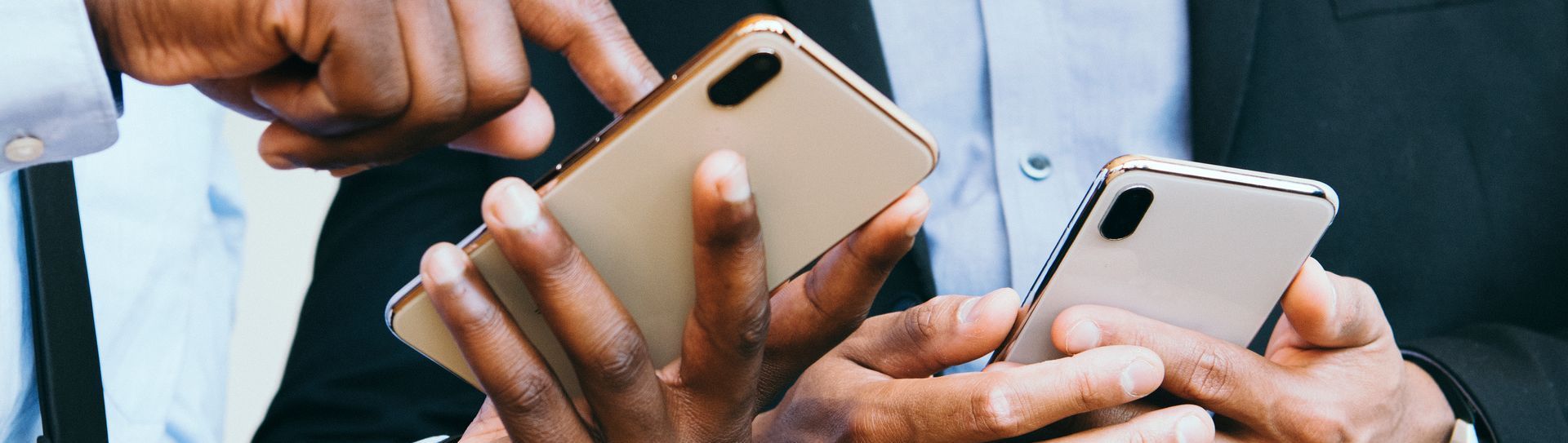 Two men are holding cell phones and exchanging contact information at a networking event.