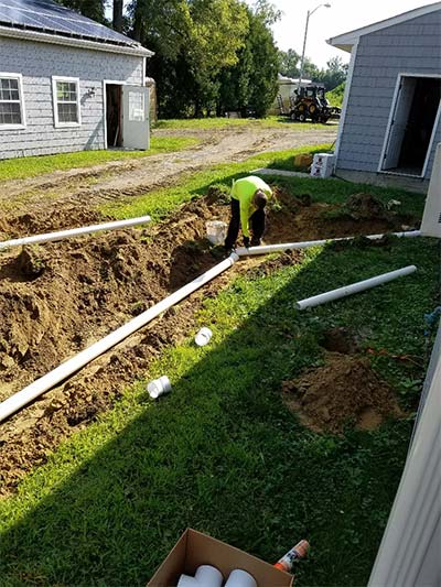 Portalbe Toilet Company — Worker Installing Pipes in North Hanover, NJ