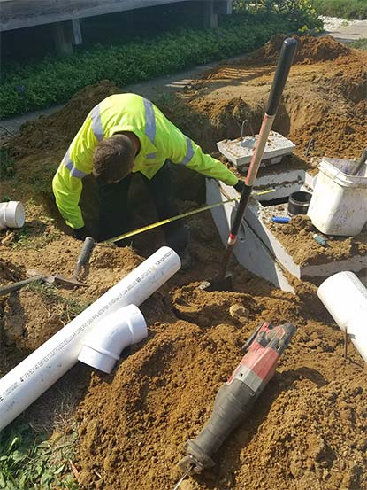 Toilet Company — Worker Measuring Space in Septic Tank in North Hanover, NJ