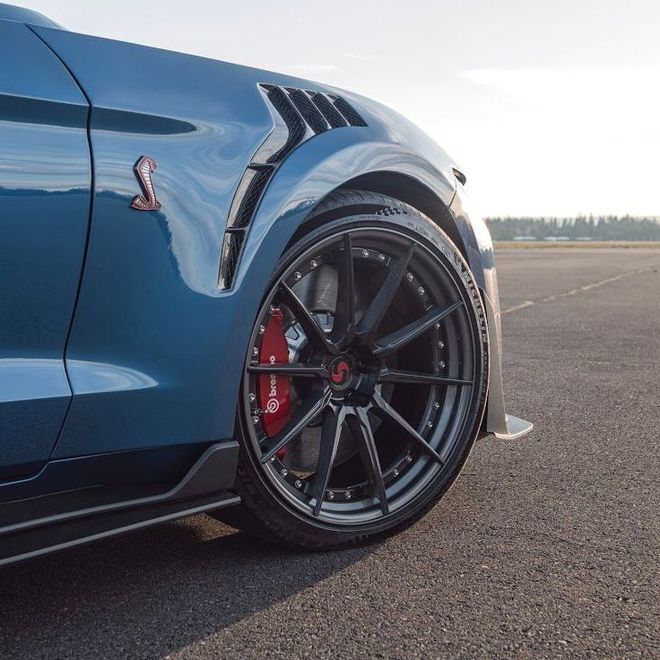 A blue ford mustang with red brembo brake calipers