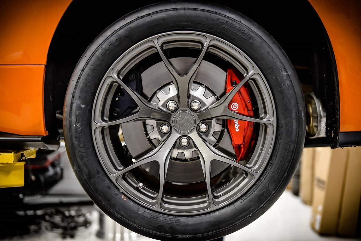 A close up of a car wheel on a lift.