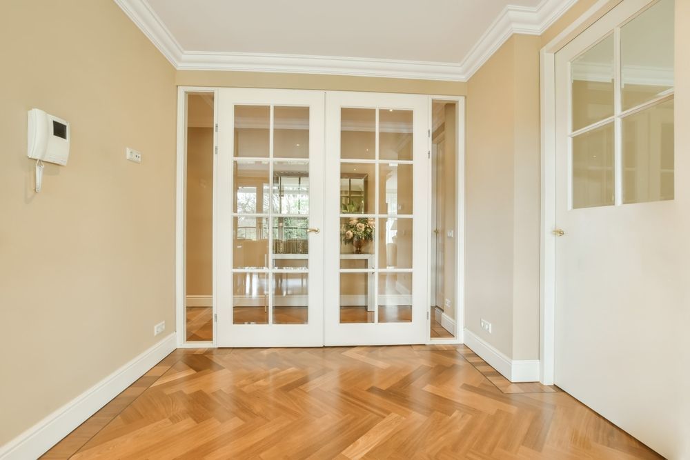 An empty room with hardwood floors and french doors