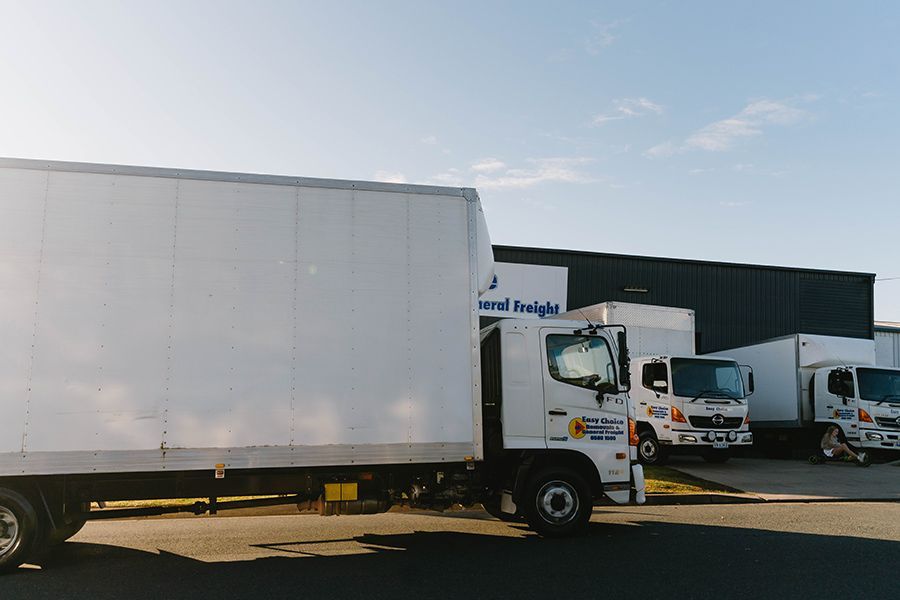 White Freight Trucks Parked in Front of A Building — Easy Choice Removals and General Freight In Port Macquarie, NSW