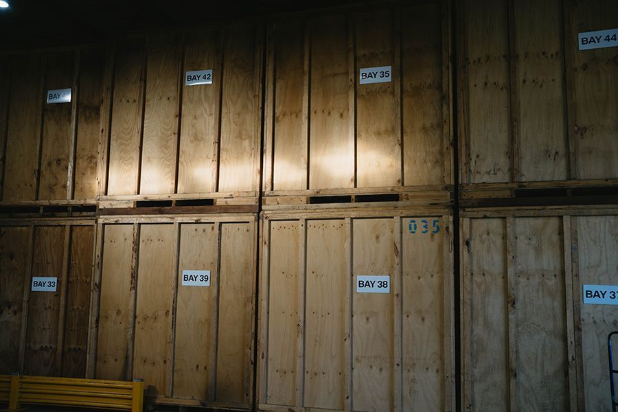 Wooden Storage Crates Stacked Against A Wall With White Labels  — Easy Choice Removals and General Freight In Port Macquarie, NSW