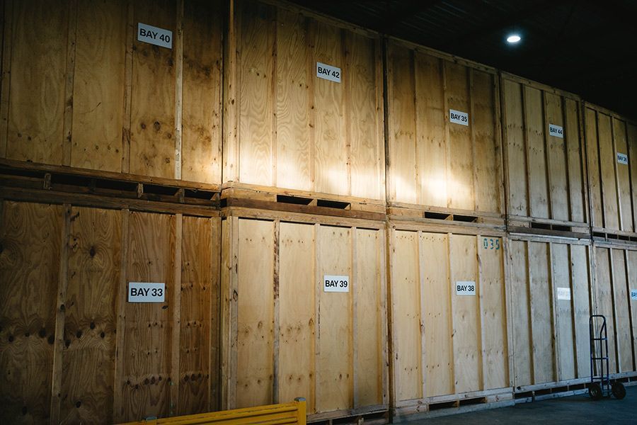 Wooden Storage Units Stacked In A Warehouse With Labels — Easy Choice Removals and General Freight In Port Macquarie, NSW
